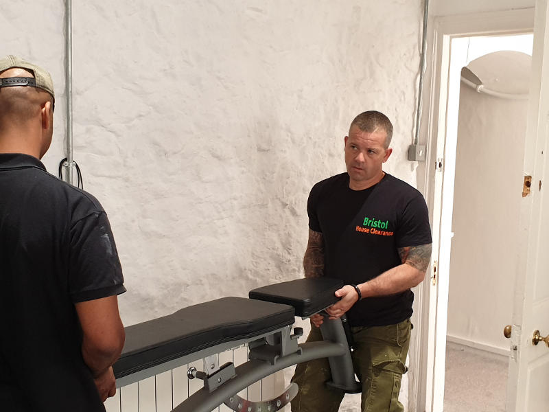 Image of two operatives carrying equipment out of a room