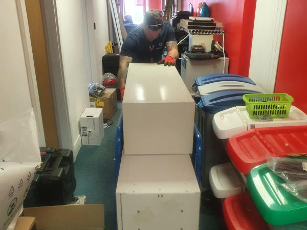 Clearance operative removing office furniture and assorted waste from a commercial property